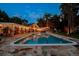 Sparkling pool surrounded by a stone patio and lush greenery, creating a serene outdoor retreat for relaxation and entertainment at 16205 Sentry Woods Ct, Odessa, FL 33556