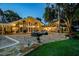 Beautiful backyard with pool, outdoor seating, stone patio, and mature trees creating an inviting outdoor living space at 16205 Sentry Woods Ct, Odessa, FL 33556