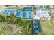 Aerial view of a recreational area showcasing tennis courts, a pool, a playground, and green spaces at 1914 Sassafras Dr, Wesley Chapel, FL 33543