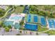 Aerial view of a community area with a pool, tennis courts, a playground, and lush landscaping at 1914 Sassafras Dr, Wesley Chapel, FL 33543