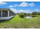 A spacious, grassy backyard that extends to a serene pond, perfect for outdoor relaxation and nature viewing at 1914 Sassafras Dr, Wesley Chapel, FL 33543