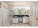 An elegant bathroom featuring double sinks, granite countertops, and a glass-enclosed shower at 1914 Sassafras Dr, Wesley Chapel, FL 33543