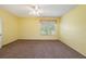 A sunny bedroom with yellow walls, carpet floors and a ceiling fan creates a bright and inviting atmosphere at 1914 Sassafras Dr, Wesley Chapel, FL 33543