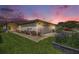 Charming home with a well-manicured lawn, vibrant flower beds, and a two-car garage under a colorful sunset sky at 1914 Sassafras Dr, Wesley Chapel, FL 33543