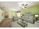 Bright living room with plush seating, decorative ceiling fan, and an open archway to the dining area at 1914 Sassafras Dr, Wesley Chapel, FL 33543