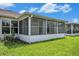 Enclosed sunroom area surrounded by windows and lawn at 1914 Sassafras Dr, Wesley Chapel, FL 33543