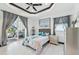 Bedroom with a tray ceiling, fan, tiled floors, sliding glass door to the outside, and picture window at 200 Eppinger Dr, Port Charlotte, FL 33953