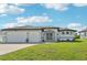 Charming single-story home featuring a two-car garage, landscaped front yard, and a welcoming entrance under a sunny sky at 200 Eppinger Dr, Port Charlotte, FL 33953