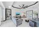 Open-concept living area showcasing stylish furniture, a ceiling fan, and doors leading to other rooms and outdoor spaces at 200 Eppinger Dr, Port Charlotte, FL 33953