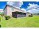 The backyard features a screened-in porch and a lush green lawn with privacy landscaping at 208 English Heritage Pl, Dover, FL 33527