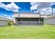 The backyard features a screened-in porch and a lush green lawn, perfect for outdoor enjoyment at 208 English Heritage Pl, Dover, FL 33527