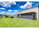 Spacious backyard with a screened-in porch, lush green lawn, and well-maintained landscaping at 208 English Heritage Pl, Dover, FL 33527