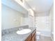 A bathroom featuring a granite countertop vanity and a shower-tub combo at 208 English Heritage Pl, Dover, FL 33527