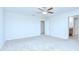Airy bedroom featuring plush carpeting, a ceiling fan, and access to an ensuite bathroom at 208 English Heritage Pl, Dover, FL 33527