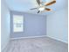 A cozy bedroom featuring neutral carpet, a ceiling fan, and a window providing natural light at 208 English Heritage Pl, Dover, FL 33527
