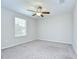 A bright bedroom featuring neutral carpet, a ceiling fan, and a window with bright sunlight at 208 English Heritage Pl, Dover, FL 33527