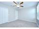 A spacious bedroom with carpet, fan, and a double-door closet for ample storage at 208 English Heritage Pl, Dover, FL 33527