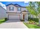 Two-story home with a two car garage, neutral colors, and a well-manicured lawn at 208 English Heritage Pl, Dover, FL 33527
