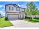 Attractive two-story home featuring a two-car garage, a red front door, and nice landscaping at 208 English Heritage Pl, Dover, FL 33527