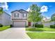 Charming two-story home with a well-manicured lawn, landscaping, and a two-car garage at 208 English Heritage Pl, Dover, FL 33527