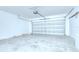 A spacious garage with a large metal door, ready for parking and storage at 208 English Heritage Pl, Dover, FL 33527