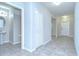 Hallway with tile floors leads to bathroom, entry door and other rooms at 208 English Heritage Pl, Dover, FL 33527