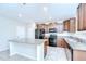 Eat-in kitchen featuring a granite counter island, dark cabinets, and stainless steel appliances at 208 English Heritage Pl, Dover, FL 33527