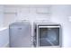 Functional laundry area with modern washer and dryer appliances, as well as metal shelving above at 208 English Heritage Pl, Dover, FL 33527