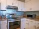 Kitchen with stainless steel appliances, tile backsplash, granite counters and white cabinets at 2333 Feather Sound Dr # B609, Clearwater, FL 33762