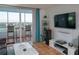 Bright living room with balcony, tile floors, entertainment center and comfortable seating at 2333 Feather Sound Dr # B609, Clearwater, FL 33762