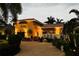 Beautiful two-story home at twilight with a brick driveway and lush landscaping and lovely front porch at 243 Snell Isle Ne Blvd, St Petersburg, FL 33704