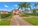 Inviting two-story home showcasing meticulous landscaping and a brick-paved driveway leading to a single garage at 243 Snell Isle Ne Blvd, St Petersburg, FL 33704