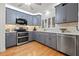 Modern kitchen with stainless steel appliances, gray cabinetry, and tile backsplash at 243 Snell Isle Ne Blvd, St Petersburg, FL 33704