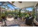 Relaxing screened-in patio with brick pavers, ceiling fan, and comfortable wicker seating amidst lush greenery at 243 Snell Isle Ne Blvd, St Petersburg, FL 33704