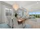 Bright dining room with a modern chandelier, white chairs, and a view into the spacious living area at 271 Monet Trl, Bradenton, FL 34212