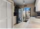 Galley-style kitchen with white cabinets, black refrigerator, and a sliding glass door to the cozy courtyard at 2922 60Th W St, Bradenton, FL 34209
