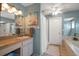 This cozy bathroom features teal walls, tub, shower, vanity, and tile floors at 3831 Yardley N Ave, St Petersburg, FL 33713