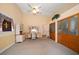 Living room with tan walls, desk, and storage featuring neutral carpet and vaulted ceilings at 3831 Yardley N Ave, St Petersburg, FL 33713
