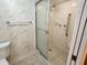 Bathroom with tile flooring, a glass-enclosed shower, and accessibility features at 400 64Th Ave # 1105, St Pete Beach, FL 33706