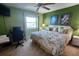Comfortable green bedroom with a bed, desk area, and bright natural lighting at 400 64Th Ave # 1105, St Pete Beach, FL 33706