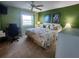 Bright green bedroom with floral bedding, a desk, and a large window view at 400 64Th Ave # 1105, St Pete Beach, FL 33706