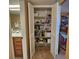 Organized linen closet with white shelving and cleaning supplies at 400 64Th Ave # 1105, St Pete Beach, FL 33706