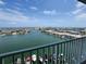 Waterfront view from a balcony featuring boats docked along the channel and buildings against a blue sky at 400 64Th Ave # 1105, St Pete Beach, FL 33706