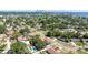 Aerial view of a neighborhood with a swimming pool, fences, and trees, with a distant city view at 4111 Whiting Se Dr, St Petersburg, FL 33705