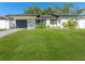 Lovely single-story home with manicured lawn, black shutters and garage door, plus mature landscaping at 4111 Whiting Se Dr, St Petersburg, FL 33705