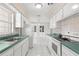 Bright kitchen with white cabinets, tiled floor and stainless steel sink at 4414 W Hanna Ave, Tampa, FL 33614
