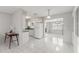Bright kitchen with white cabinets, and tile flooring open to dinning space at 4414 W Hanna Ave, Tampa, FL 33614