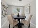Cozy dining area featuring a round table, comfortable upholstered chairs, and modern art in a neutrally decorated space at 4870 47Th N Ave, St Petersburg, FL 33714