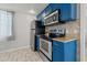 Well-equipped kitchen features blue cabinets, stainless steel appliances, and bright, efficient lighting at 4870 47Th N Ave, St Petersburg, FL 33714