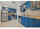 Modern kitchen with stainless steel appliances, beautiful blue cabinetry, and stone countertops, all brightly lit at 4870 47Th N Ave, St Petersburg, FL 33714
